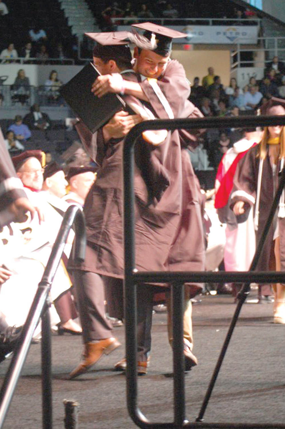 Students hug after receiving their diplomas.